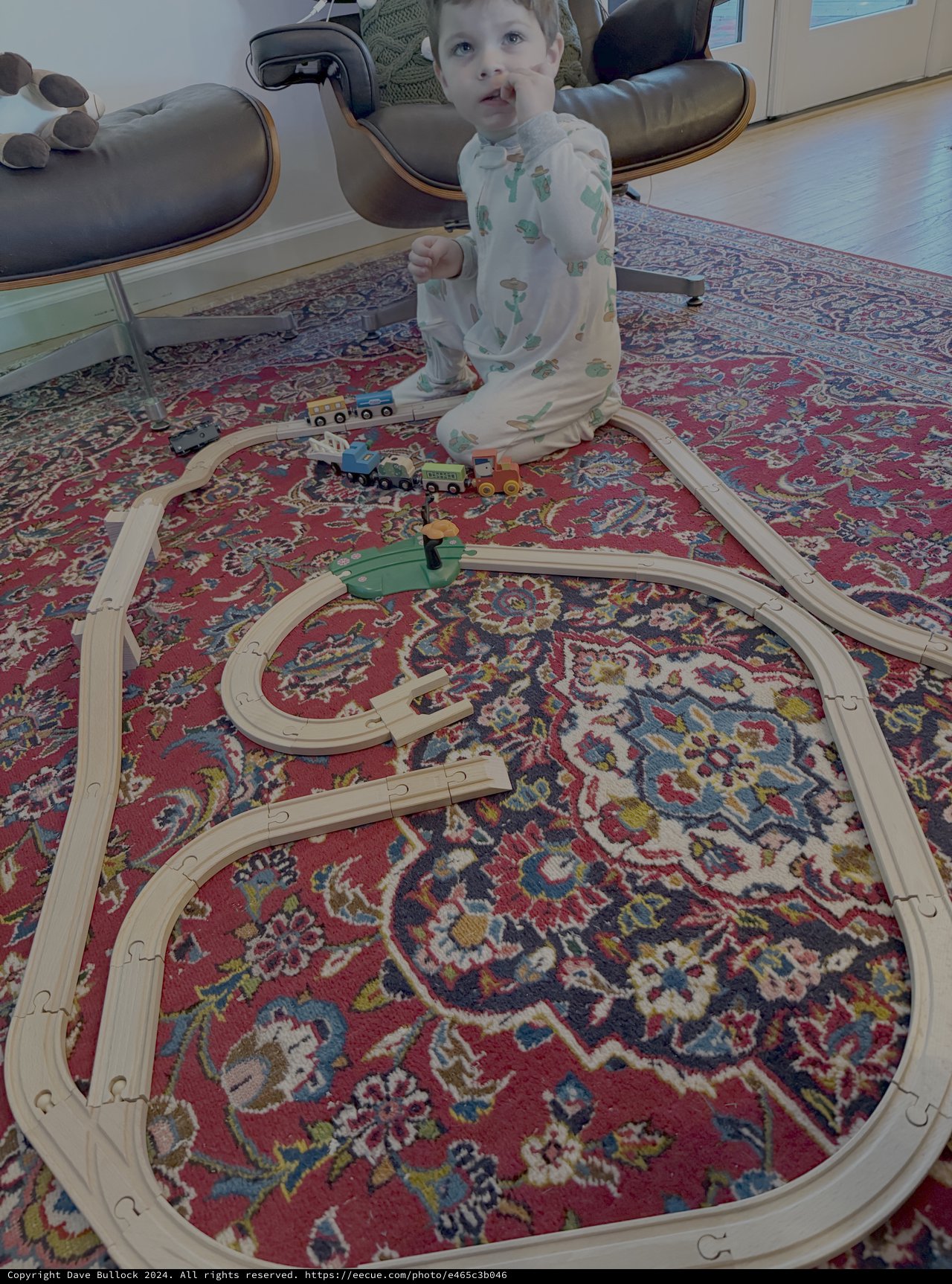 Toddler Playing with Wooden Train Set at Home