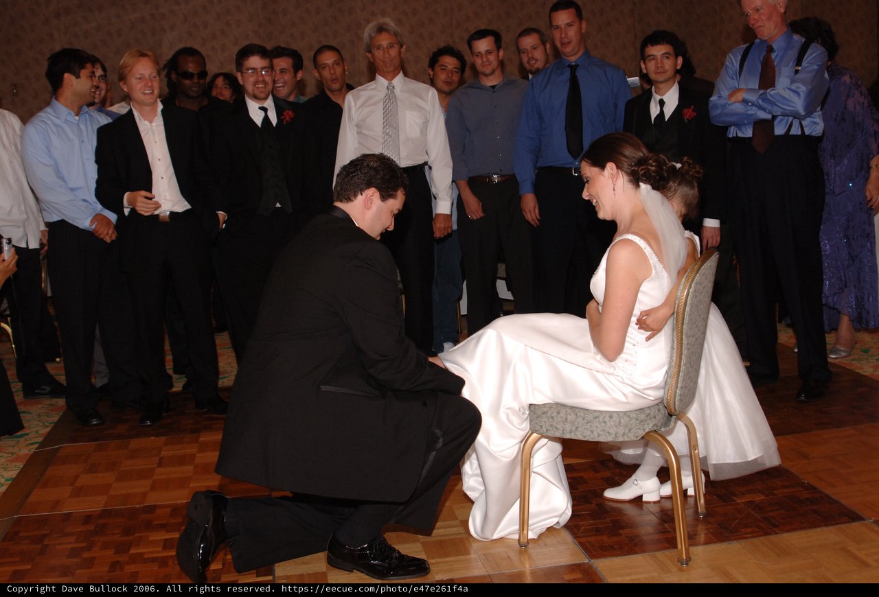 Groom Removes Garter from Bride at Wedding Reception