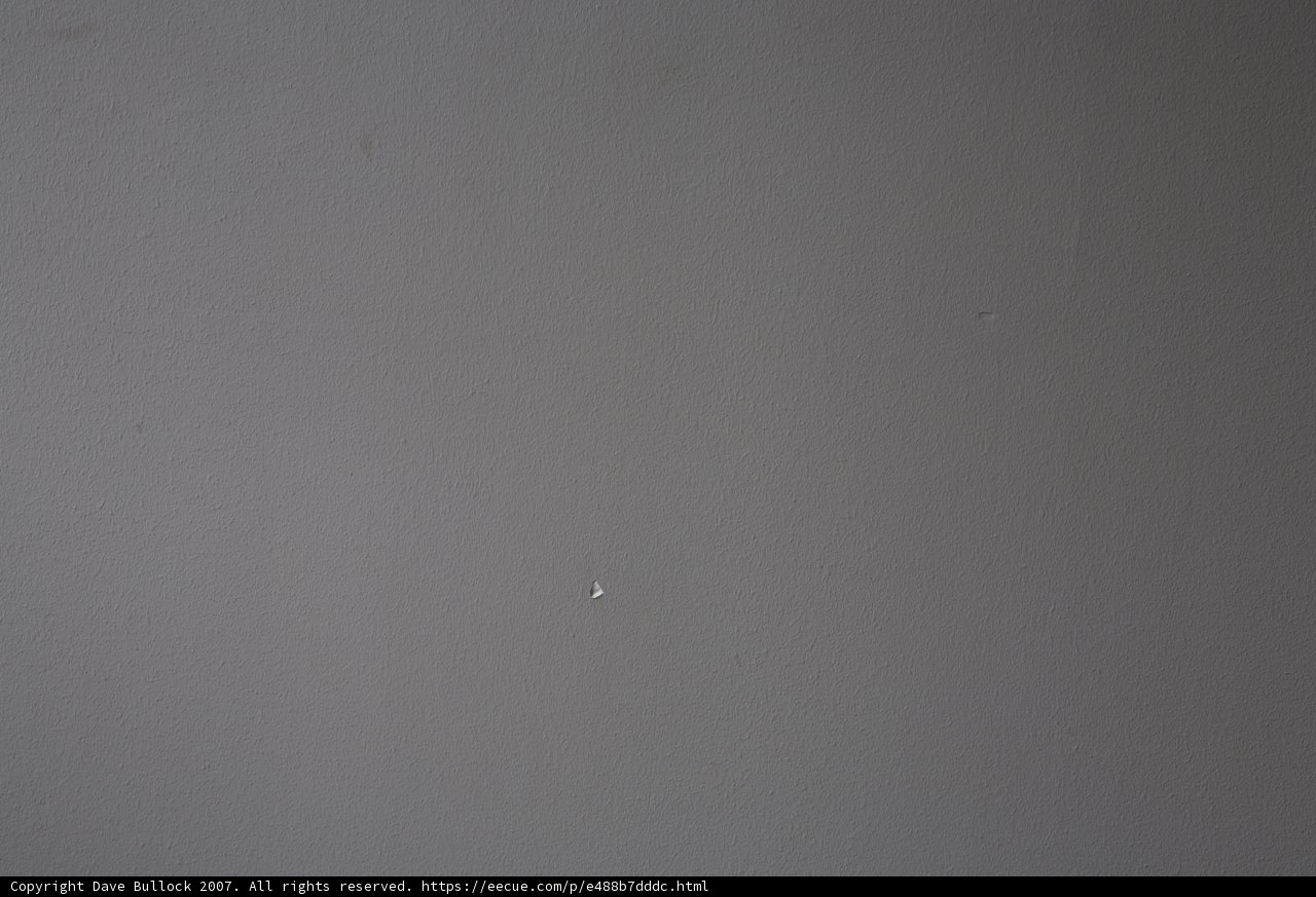 Tiny White Dot on Textured Wall