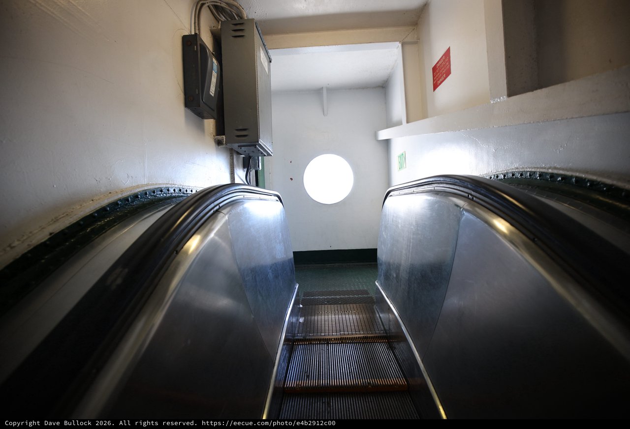 Descending Escalator into Industrial White Corridor