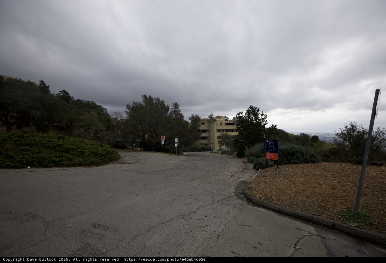 Overcast Hillside Road Leading to Multi-Story Building