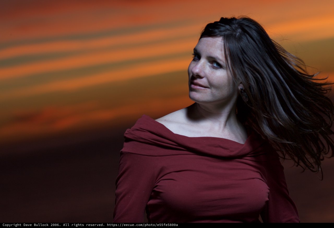 Woman in Red Beneath a Dramatic Sunset Sky