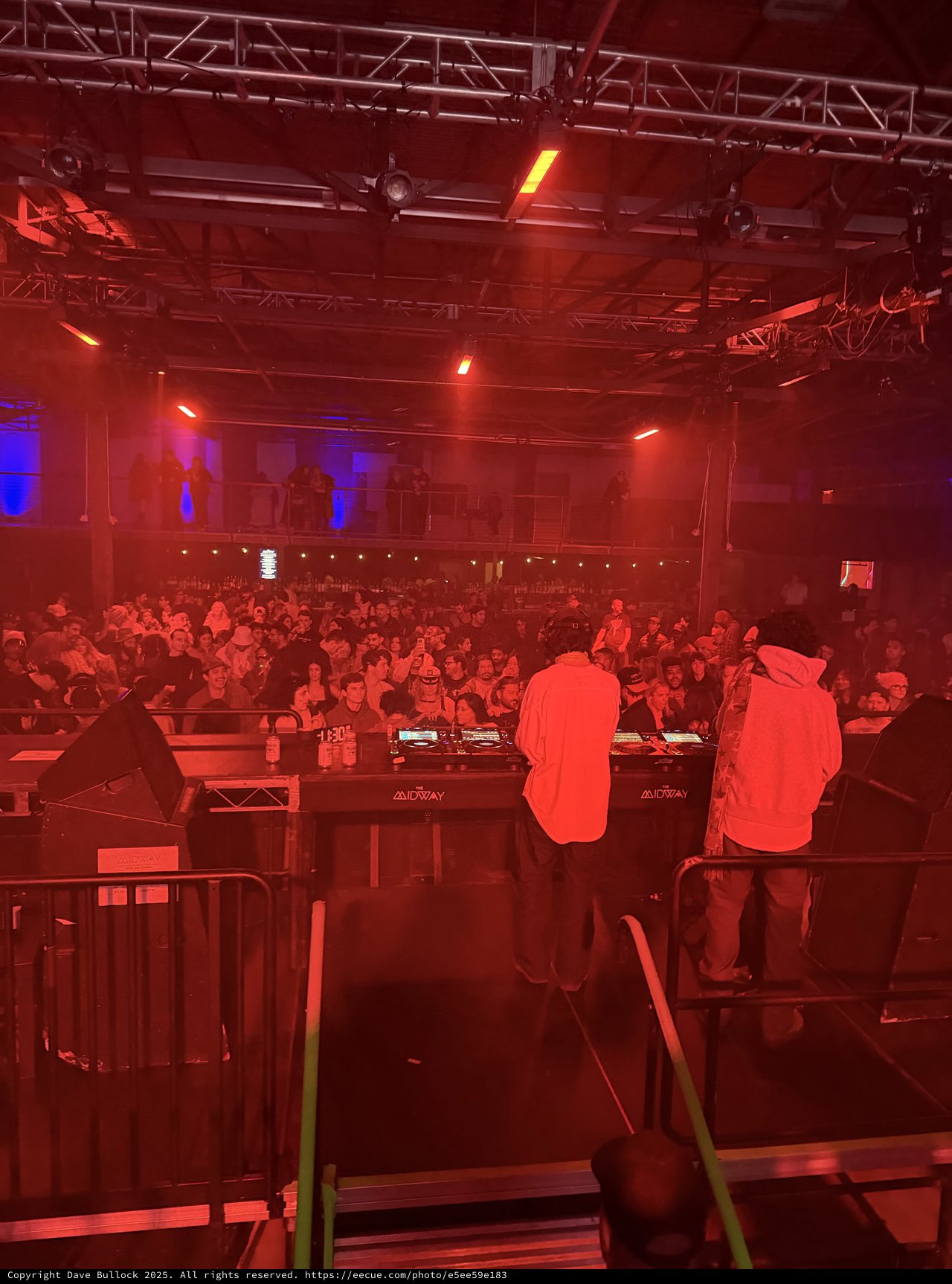 DJ Performance at Electronic Music Venue Under Red Stage Lights