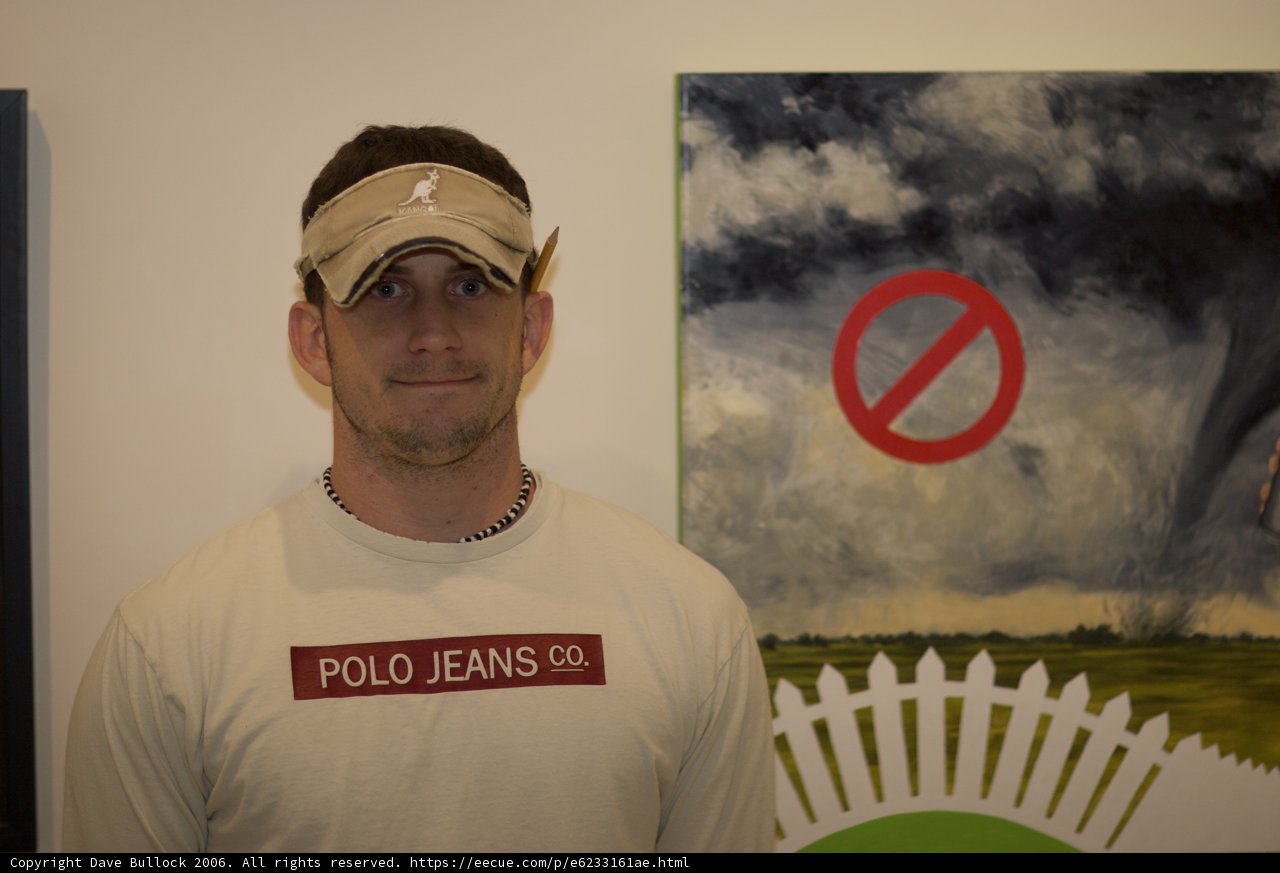 A Man in a Baseball Cap and T-Shirt Admires a Painting