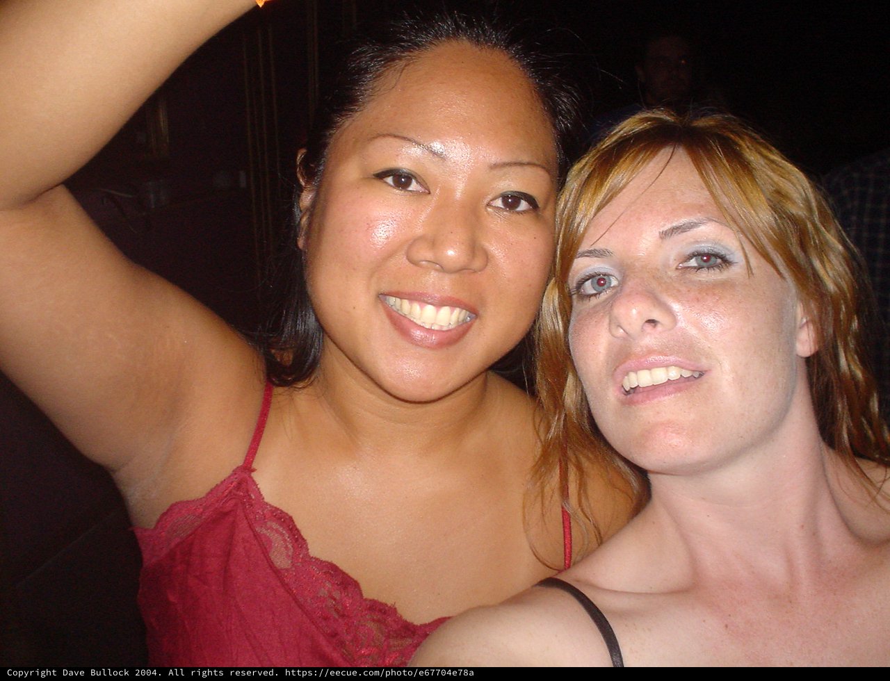 Two Friends Smiling Together at a Nighttime Event