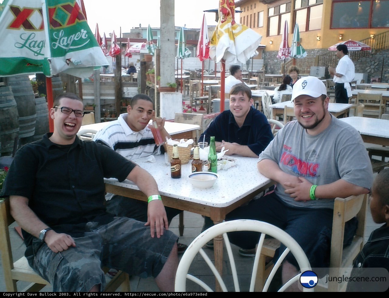 Four Men Enjoying Beer and Food at a Restaurant