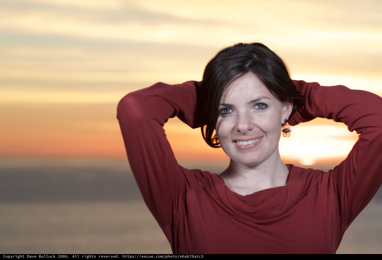 Radiant Woman Smiling at Sunset by the Sea
