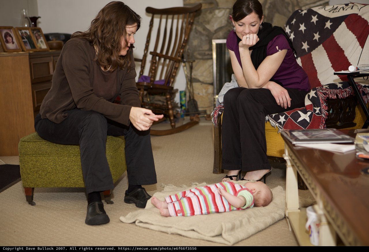 Two Women Admiring a Newborn Baby on Floor