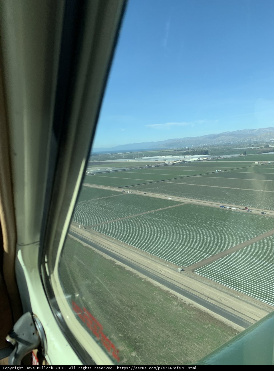 Aerial View of a Field and Highway from an Airplane Window