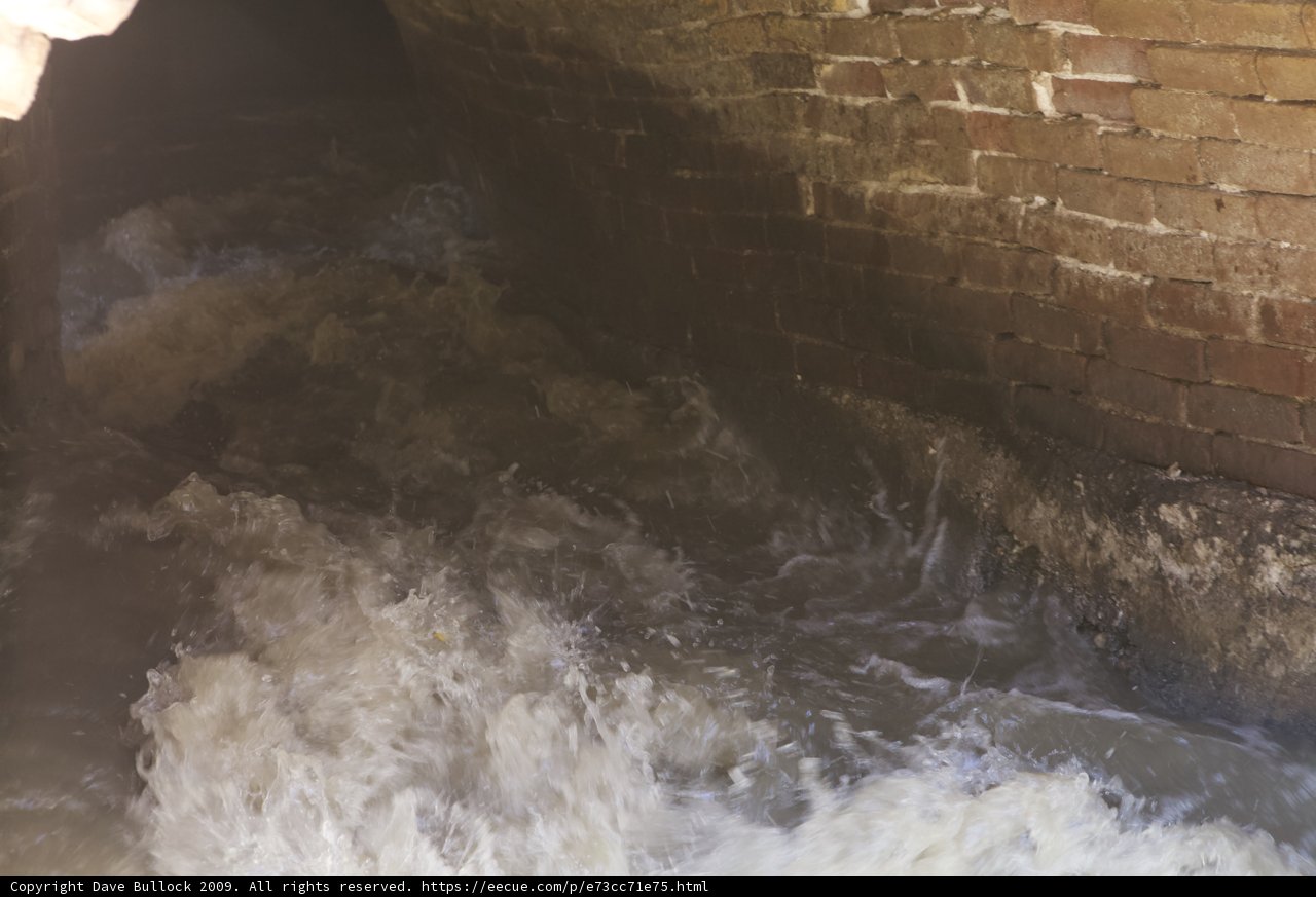 Rushing Waters Under a Brick Wall