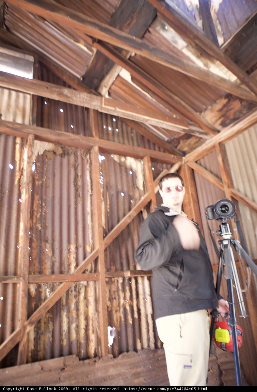 Man with Tripod Captures Wood Barn