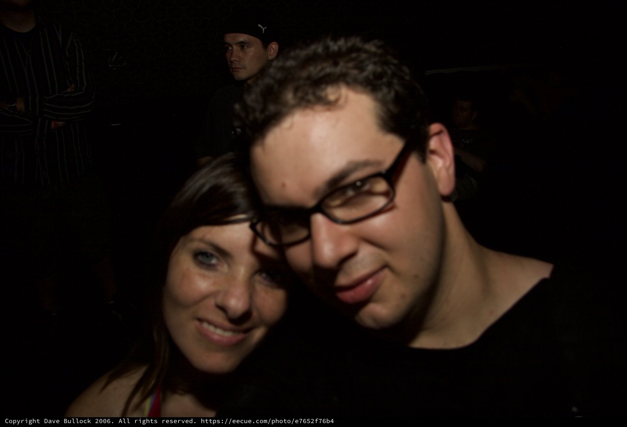 Two Friends Smiling Together at Nighttime Event