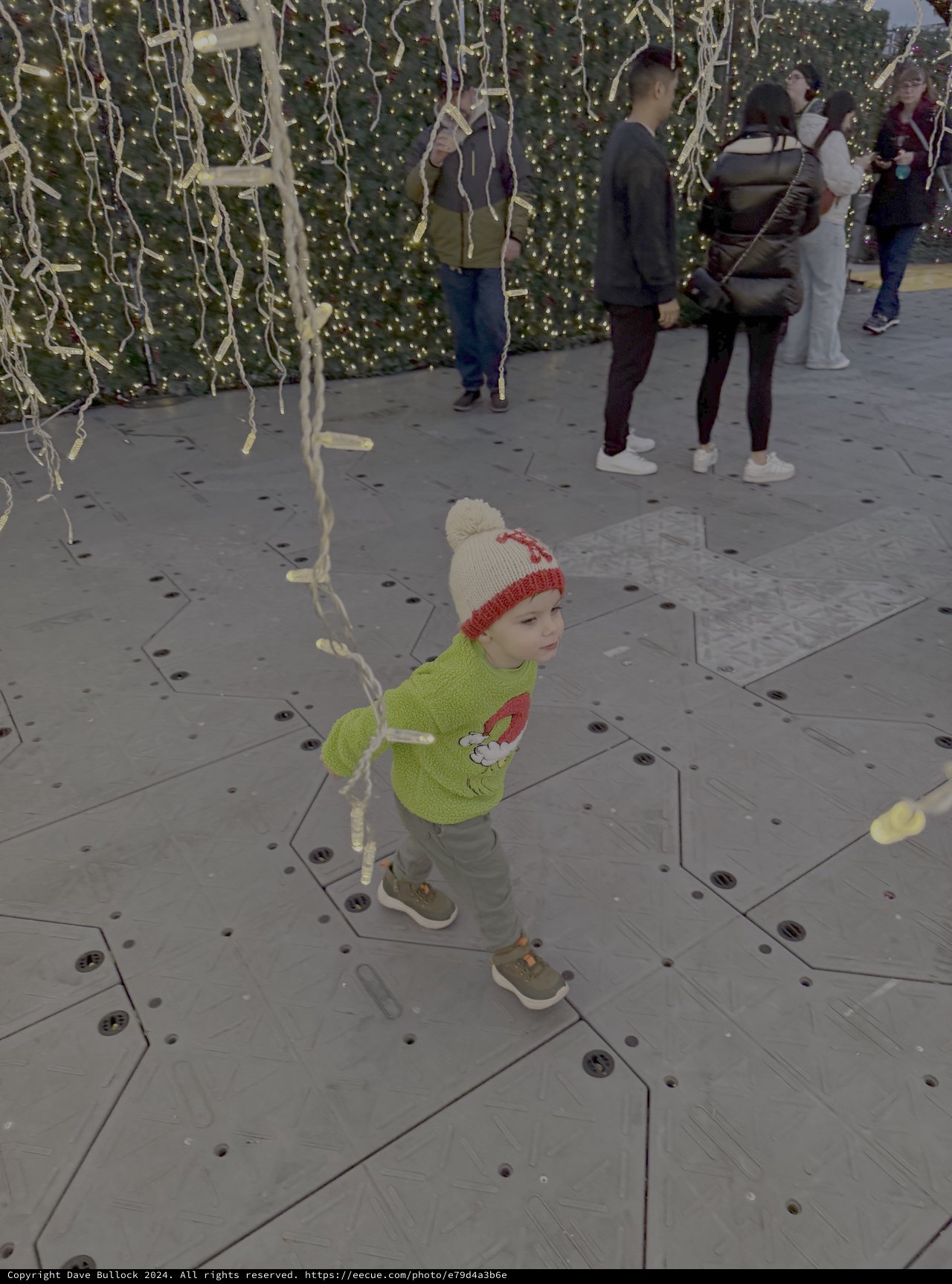 Child Playing Among Christmas Lights Display