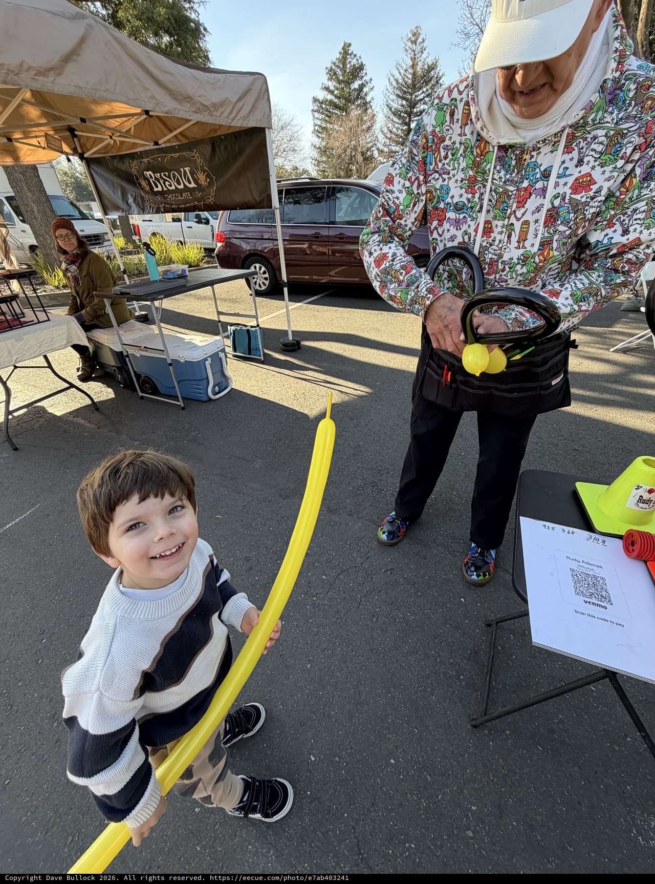 Young Boy Enjoys Balloon Sword at Community Market Event
