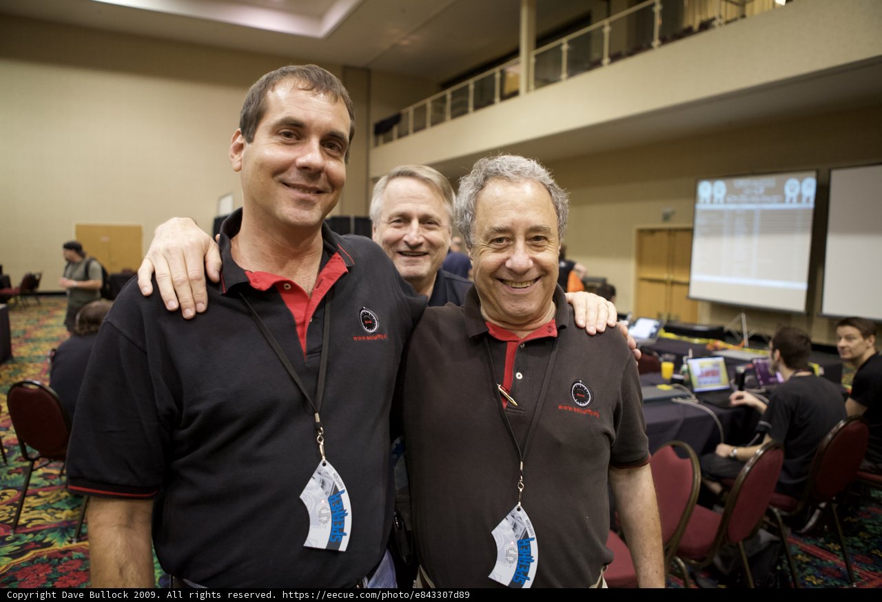 Three Men in Black Shirts and Red Ties Strike a Pose
