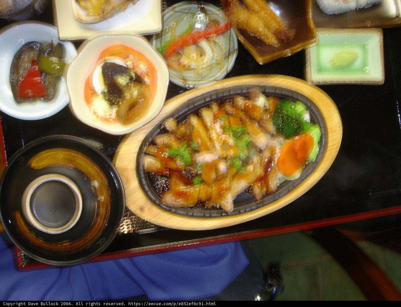 A Delicious Spread Caption: A tray filled with an assortment of dishes including soup, stew, bread and vegetables, accompanied by condiments and seasonings, showcased on a beautifully set dining table.