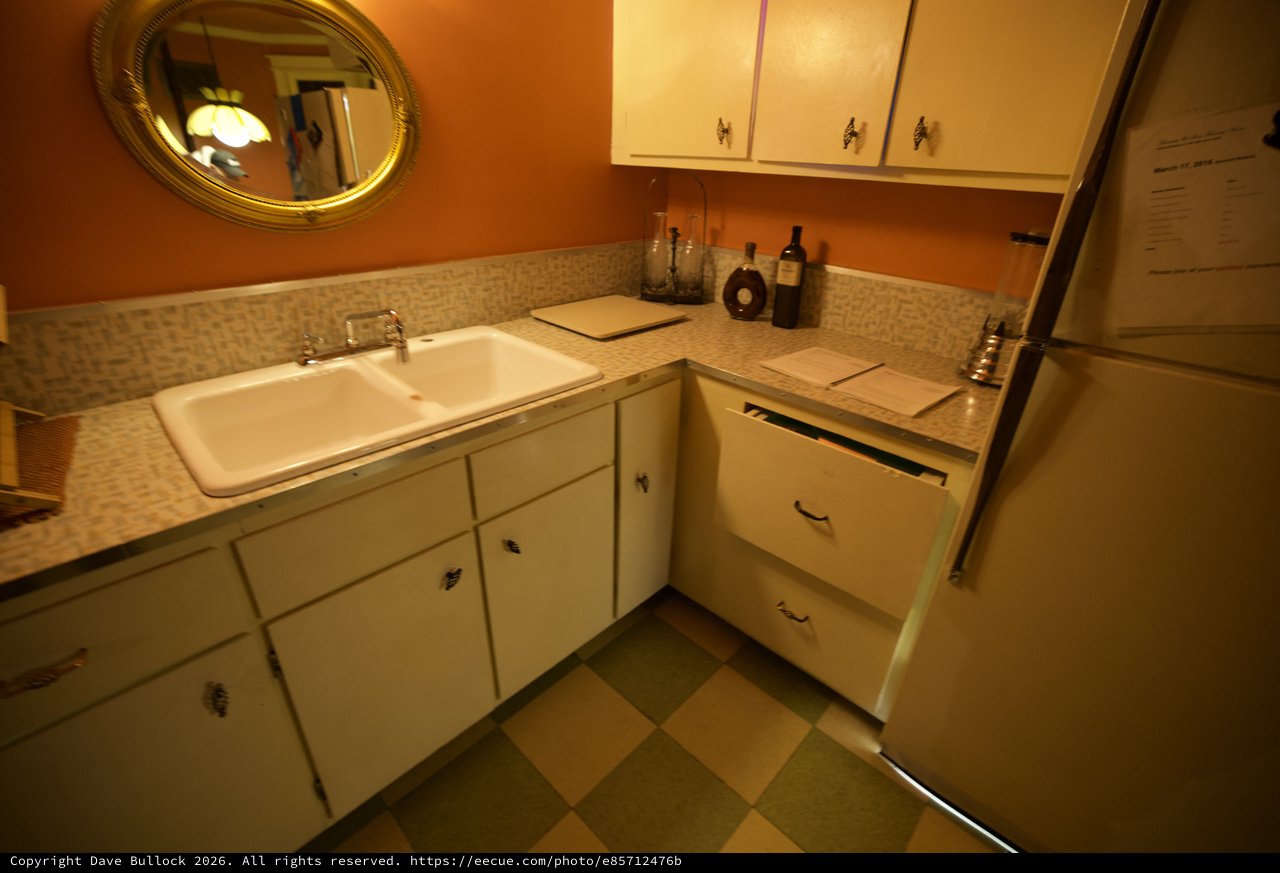 Retro Kitchen Corner with Orange Walls and Checkered Floor