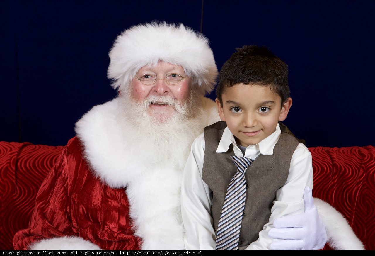 A Boy and Santa Claus Share a Couch at the APC Christmas Party