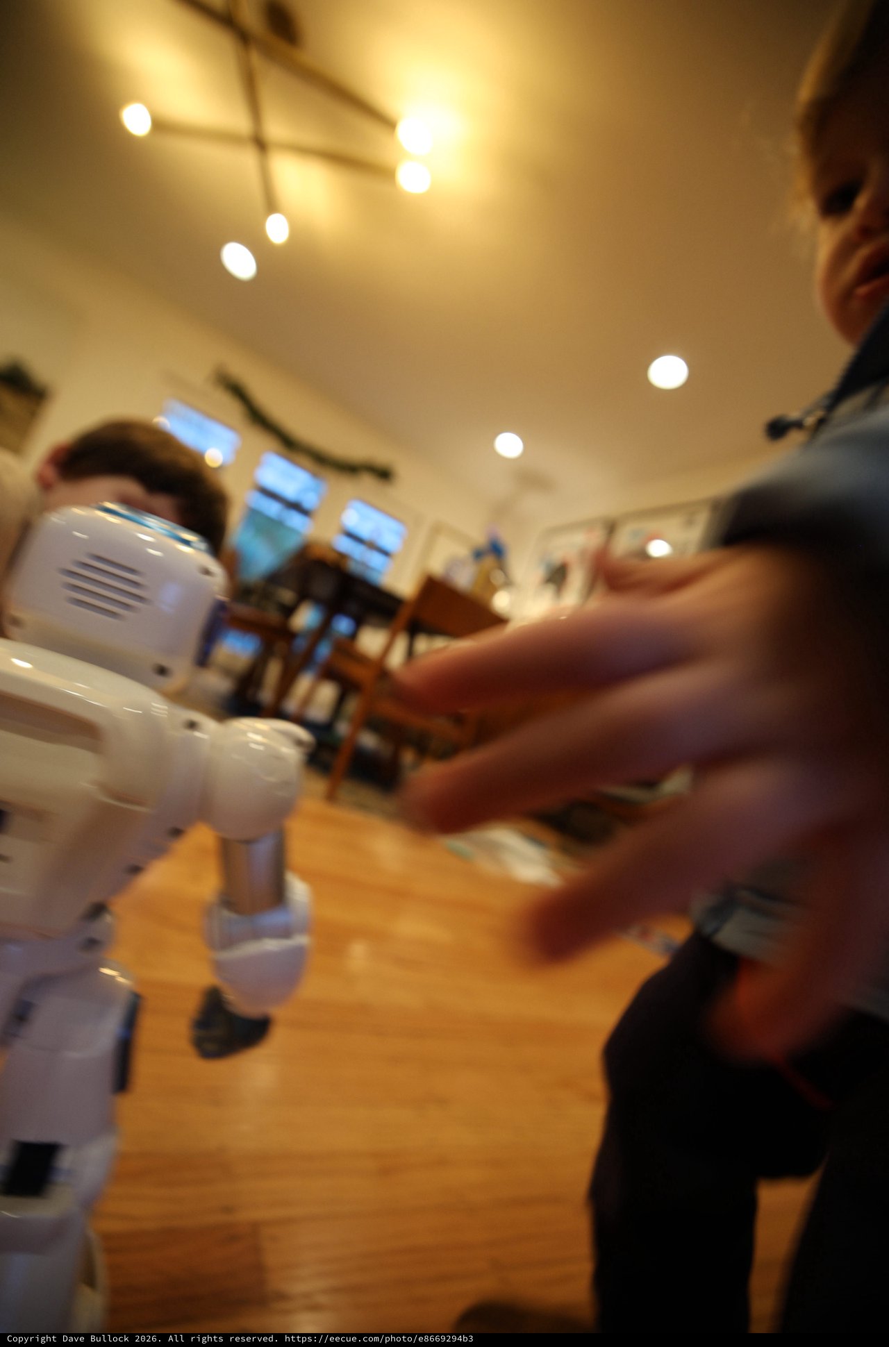 Child Interacting with Small White Robot at Home