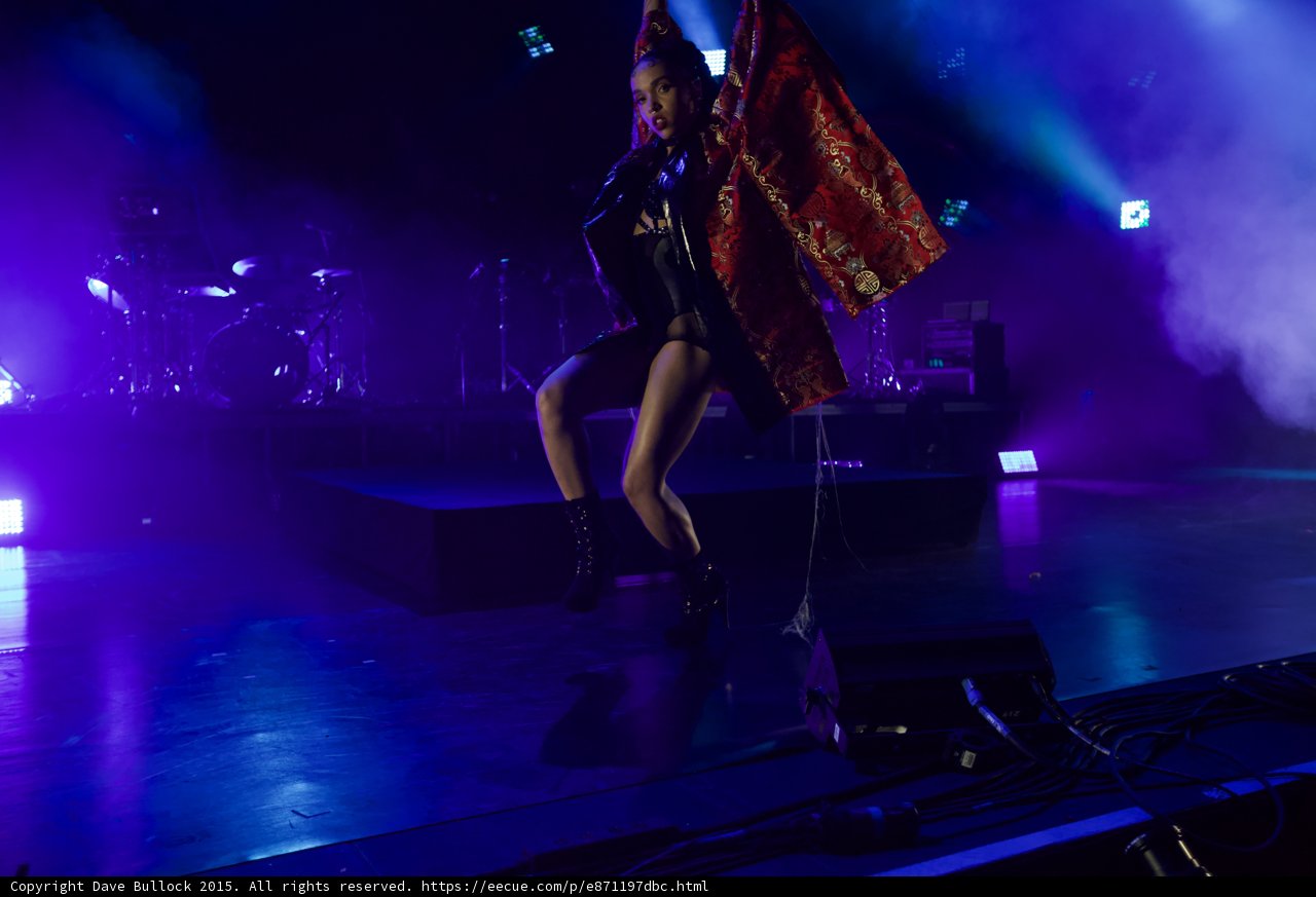 FKA twigs Dynamic Dance Pose Leg Raised Kimono Flowing One Side Red Brocade Gold Patterns Black Bodysuit Boots Face Visible Band Drums Microphone Cable