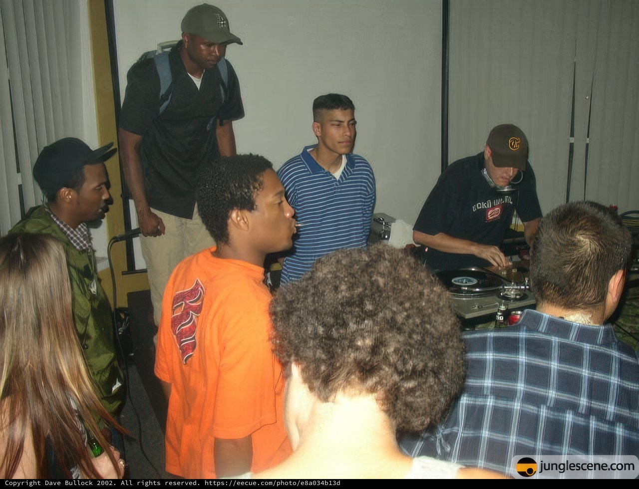 Crowd gathered around DJ at indoor venue