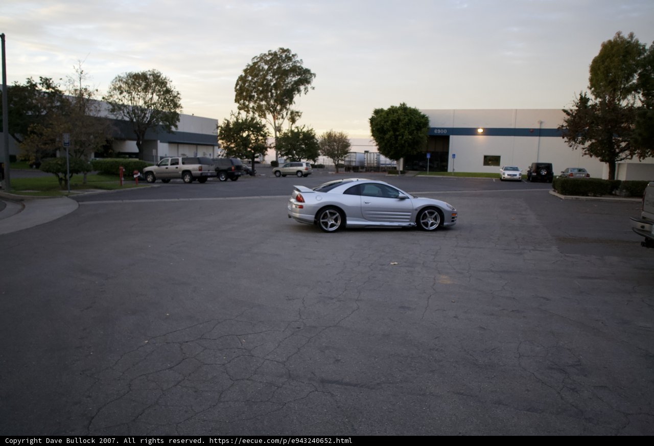 Sleek Silver Sports Car Parked in a Cloudy Parking Lot