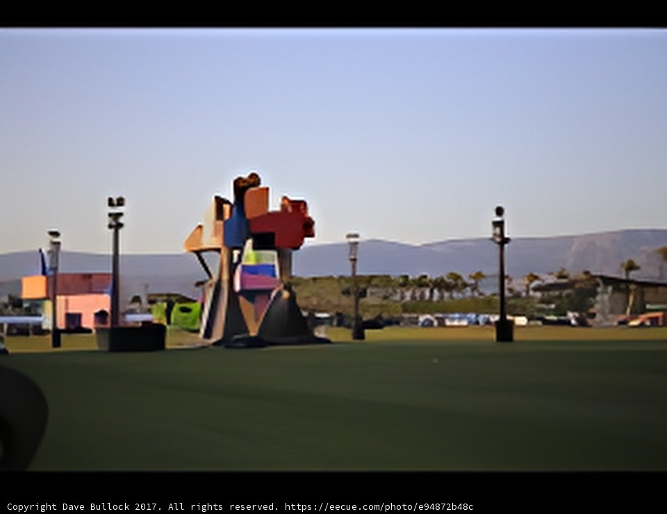Towering Sculpture in a Vast Green Field