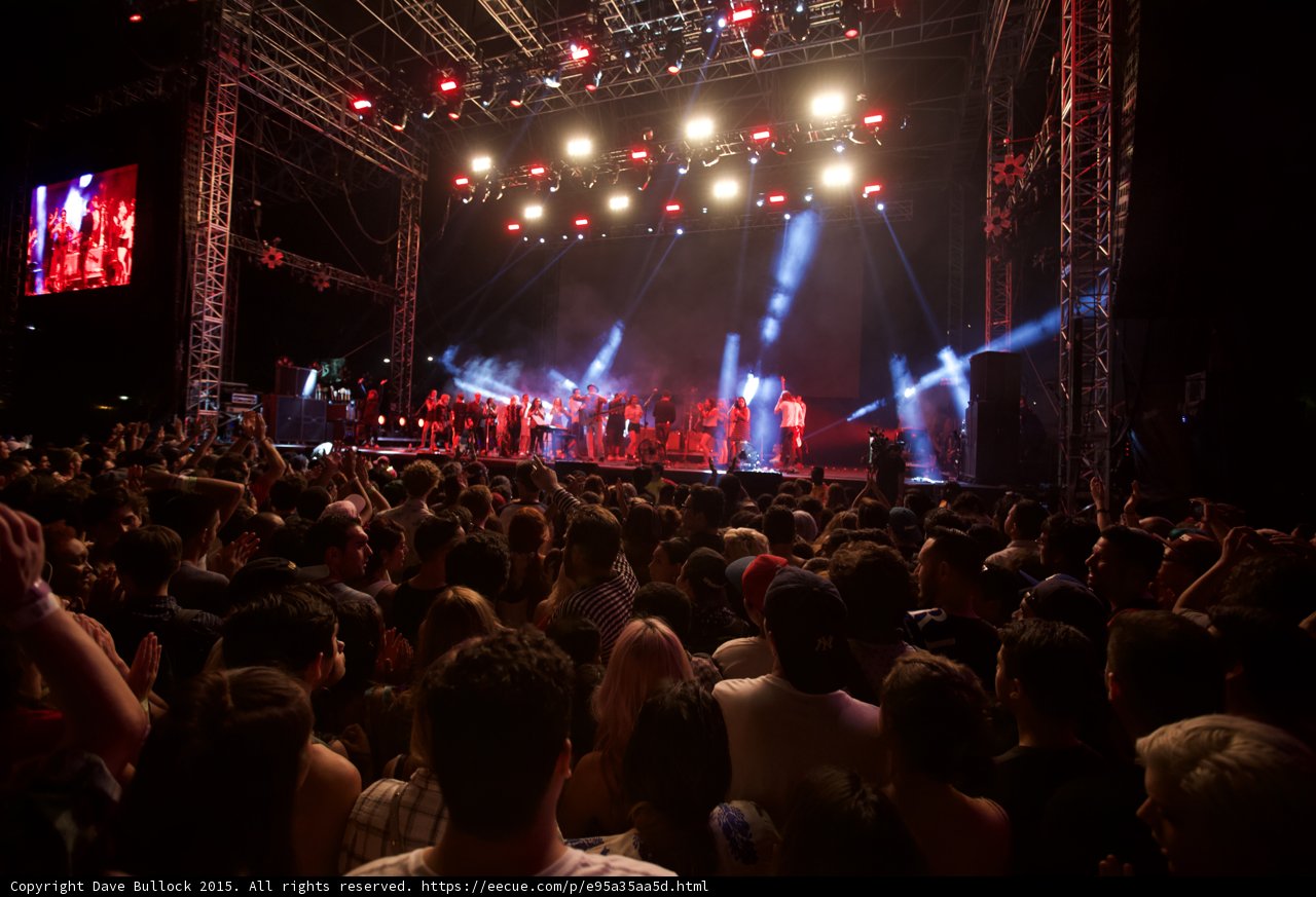 Belle and Sebastian Wide Stage Amber Lighting Spotlight Beams Clapping Fan Ensemble Crowd