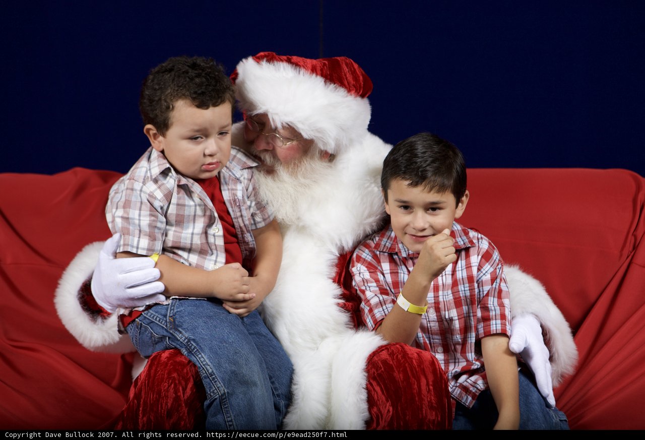 Santa Claus and Two Boys on a Festive Red Couch
