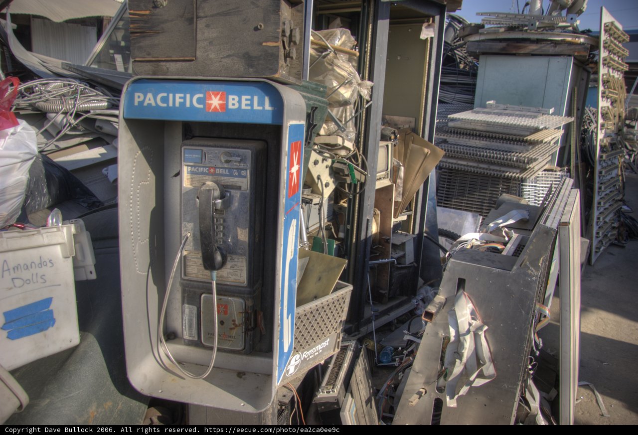 Abandoned Pay Phone amidst Electronic Junk