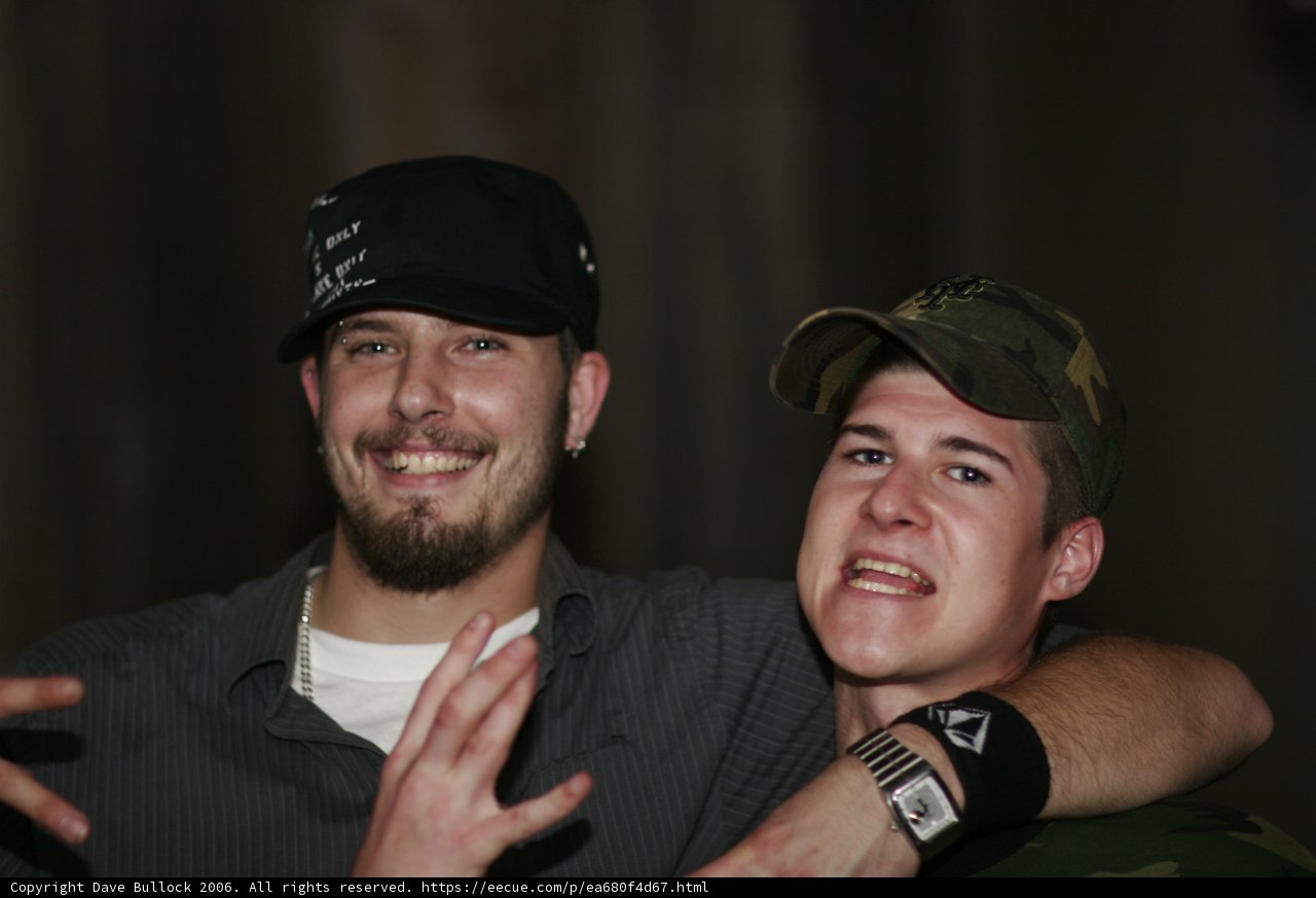 Two Hat-Wearing Men Strike a Pose