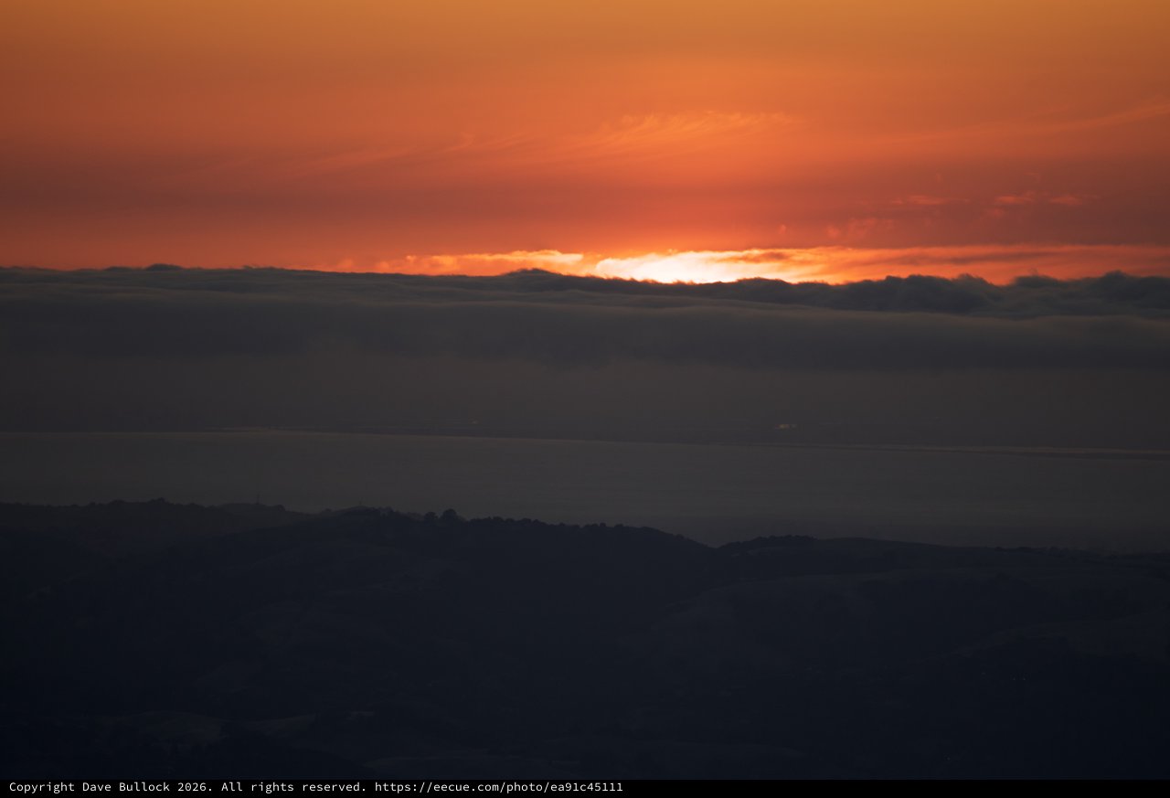 Fiery Sunset Ignites the Horizon Beyond Bay Clouds