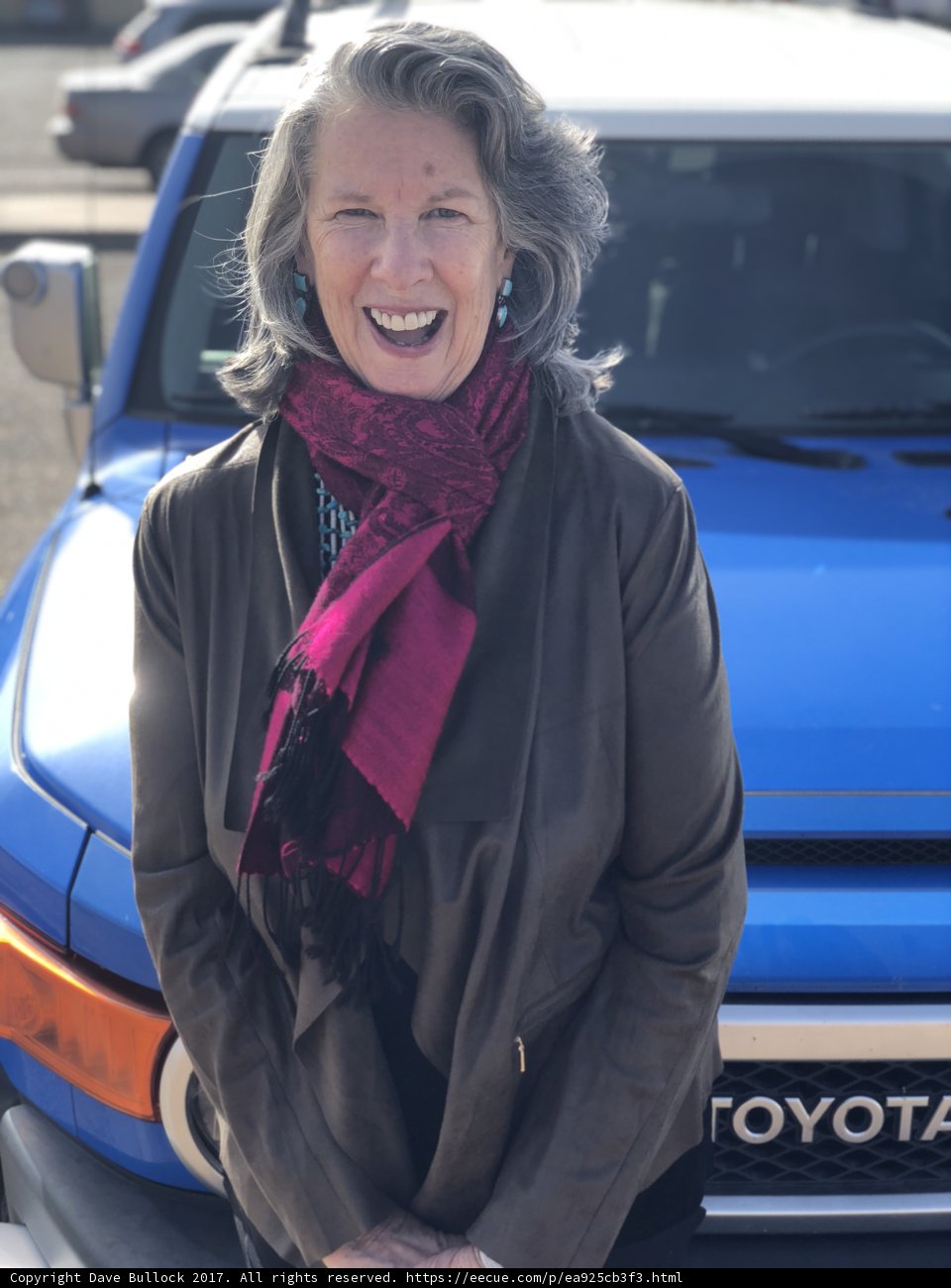 Happy Woman Poses in front of Blue Toyota Truck