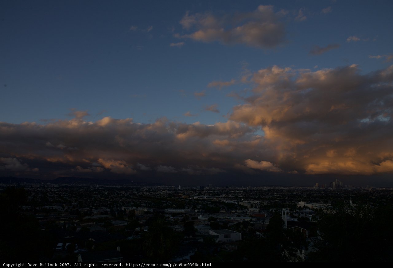 Clouds rolling in over the city at sunset