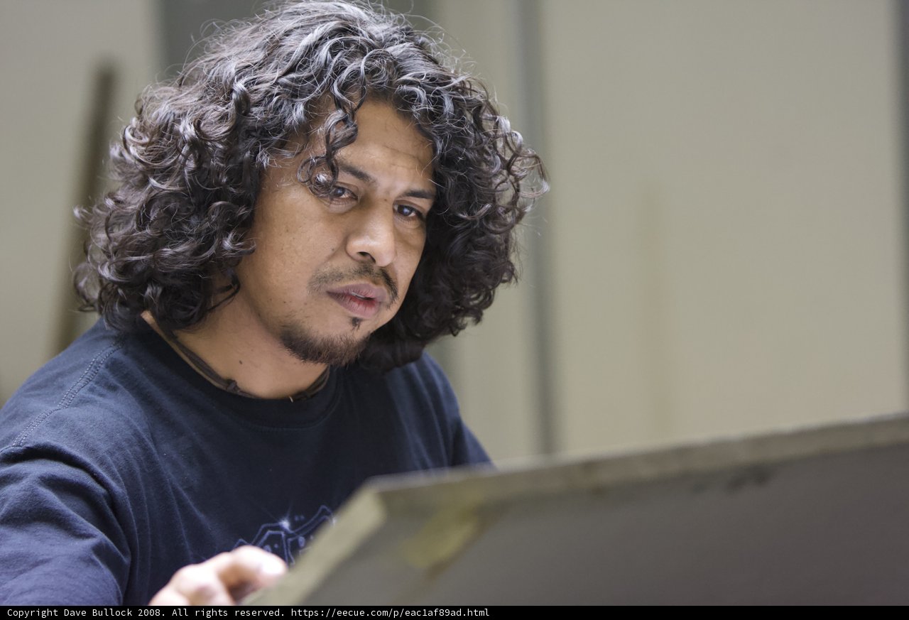 Curly-Haired Man on Laptop