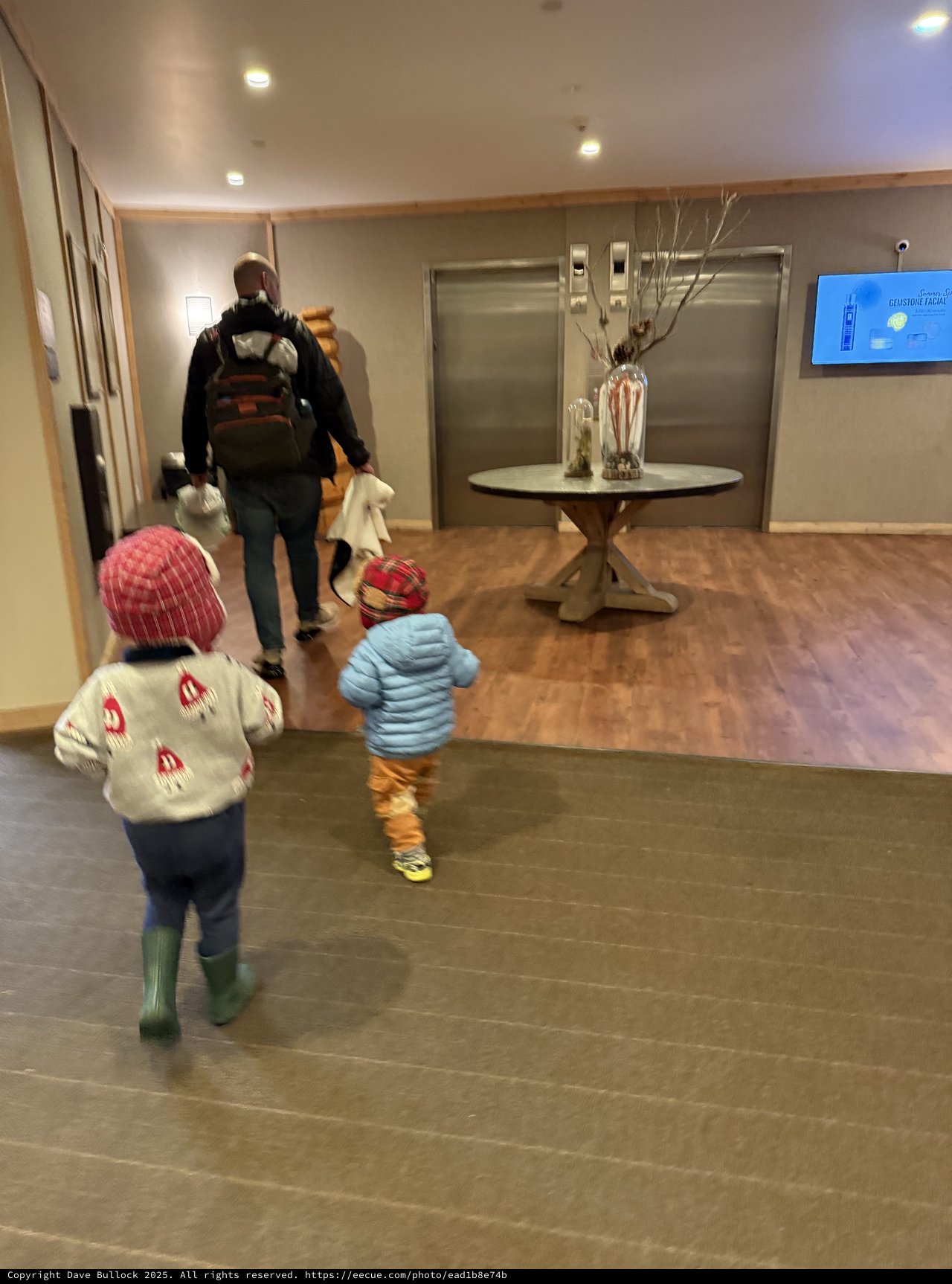 Family Rushing Through Hotel Lobby Toward Elevators