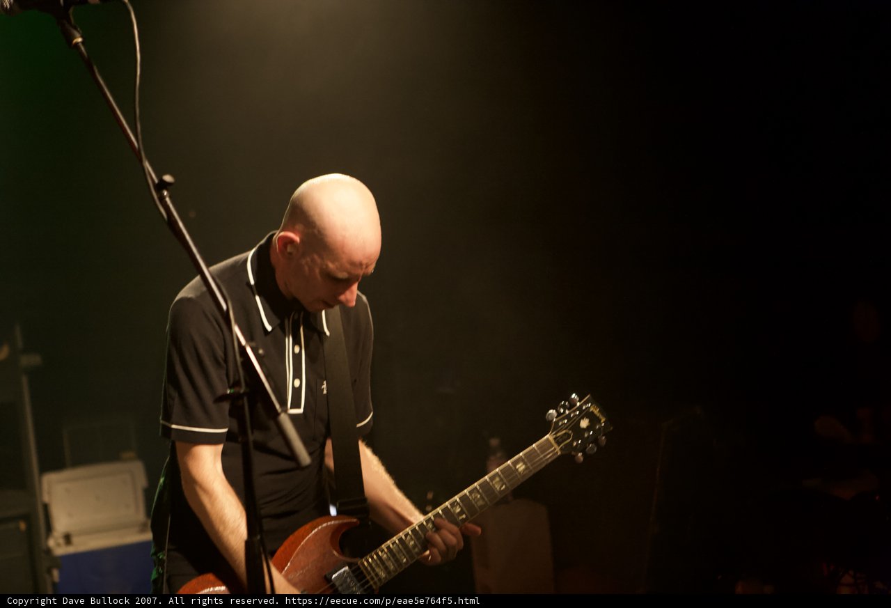 Bald Entertainer Rocks the Stage with Electric Guitar