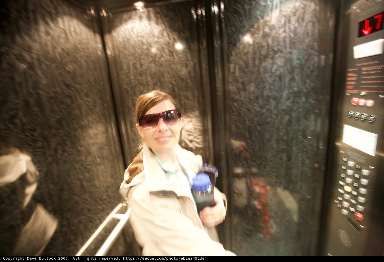 Smiling Woman in Elevator Holding Water Bottle