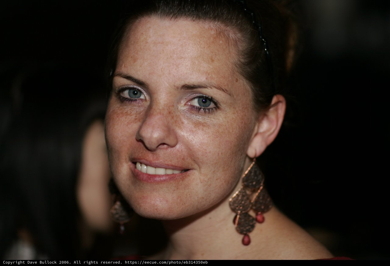 Freckled Woman Smiling at Evening Social Event