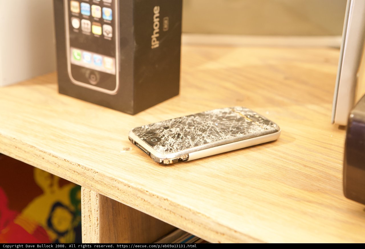 Broken iPhone Resting on Wooden Table
