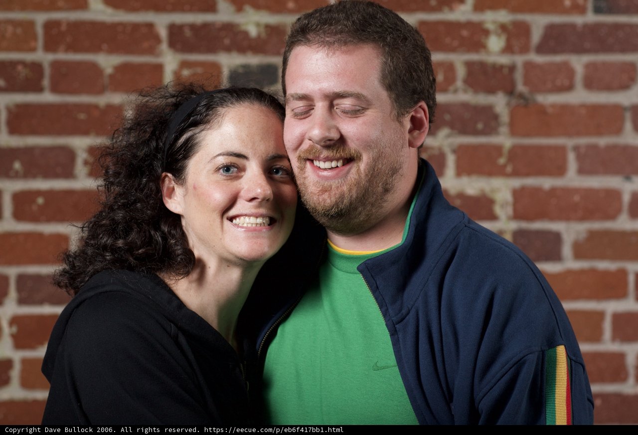 Smiling Couple in Front of Brick Wall