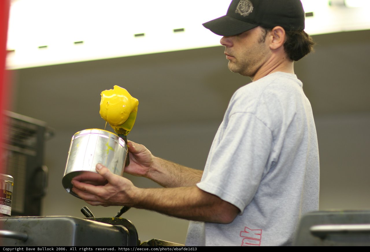 Holding a Can of Lemonade Caption: A man wearing a baseball cap and holding a yellow can of refreshing lemonade.