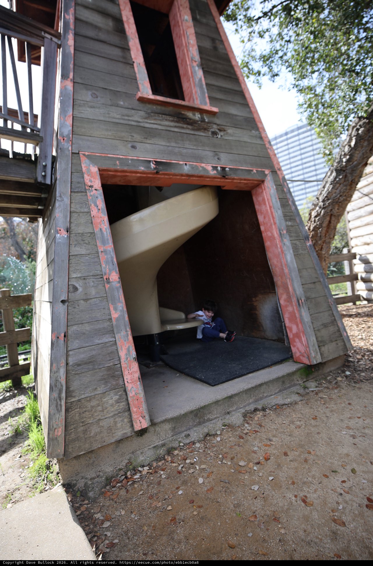 Child Playing in Weathered A-Frame Playhouse Structure