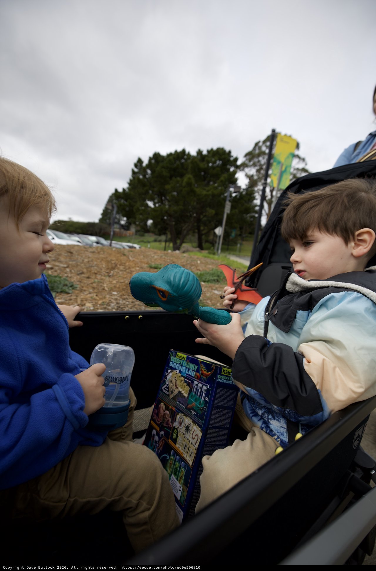 Two Young Boys Share Toys at Outdoor Playground