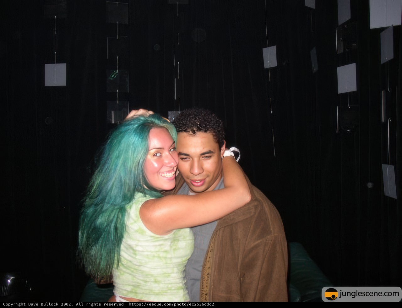 Blue-haired couple embrace on wedding day
