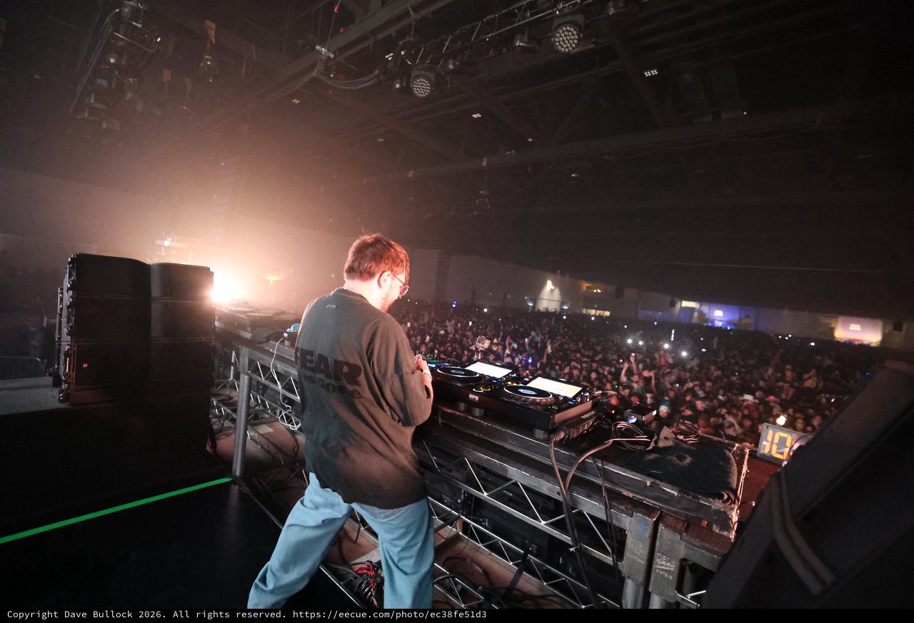 DJ Commanding a Massive Indoor Festival Crowd
