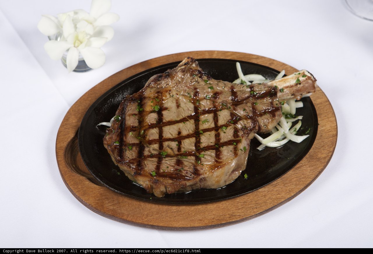 Juicy steak with caramelized onions on a sleek black plate