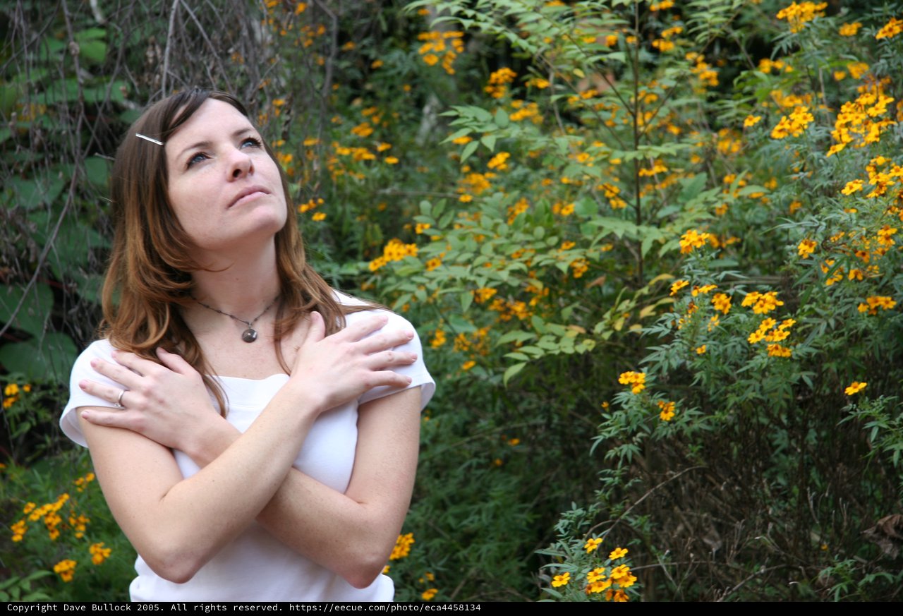 Woman in White Gazing Upward Among Yellow Wildflowers