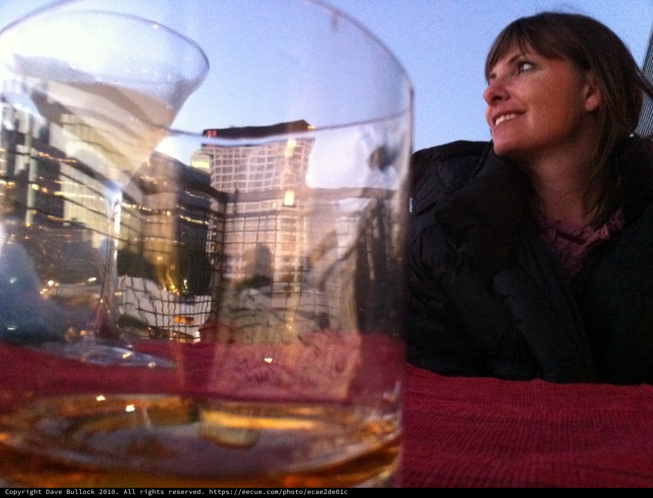 Rooftop Reverie: Woman Gazes at City Skyline at Dusk