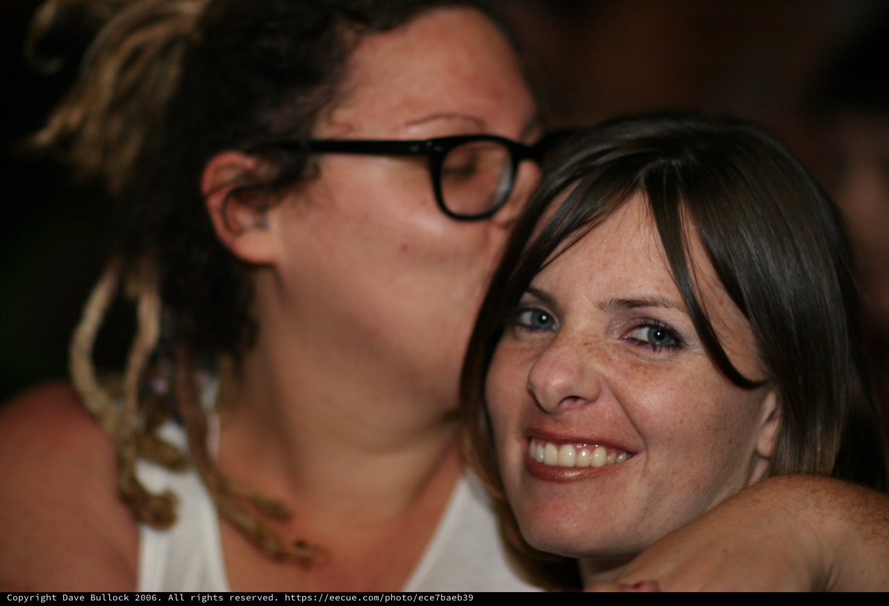 Two Friends Share a Warm Embrace at Social Gathering